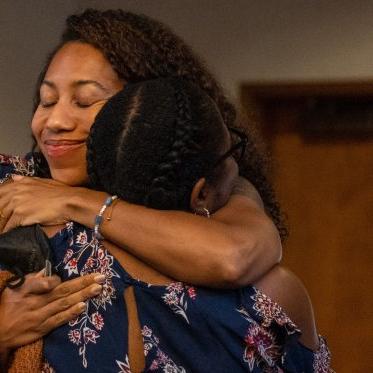 SMC faculty members hug