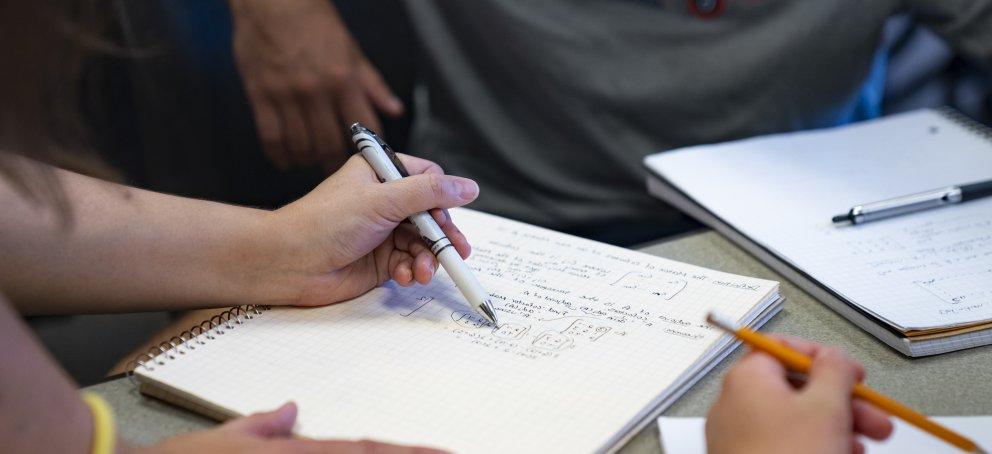 A closeup of students taking notes