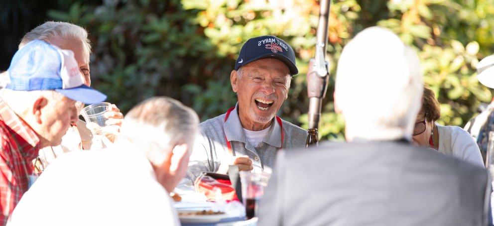 An alumnus wearing a SMC hat laughs