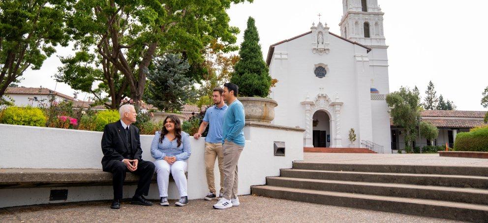 Br Thomas at statue with students