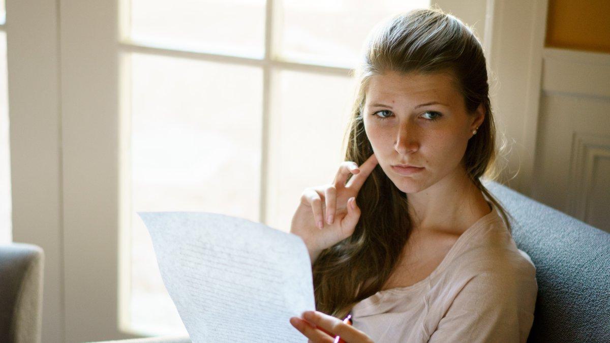 Writer holding a piece of paper in the Writing Center.