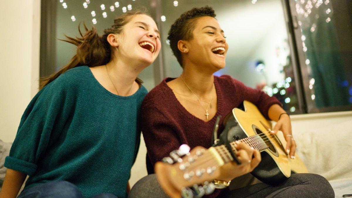 Students smiling and playing guitar